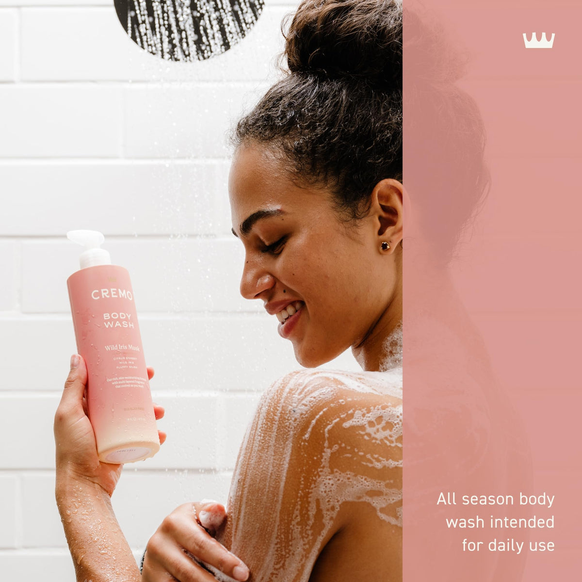Woman applying body wash to her skin with a bottle labeled 'CREMO' in a bathroom setting.