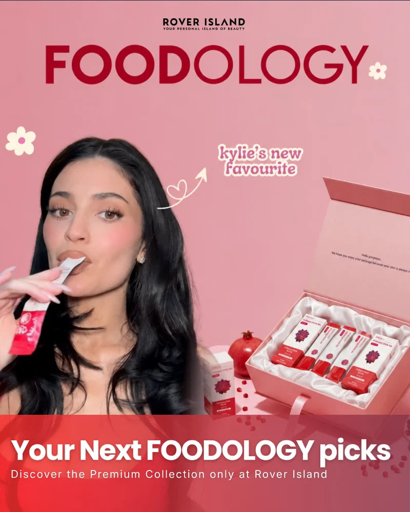 Rover Island's Foodology collection, featuring a Kylie Jenner Eating FOODOLOGY Coleology Pomegranate Jelly Stick next to an open gift box containing multiple Foodology Products. The background is a solid pink with the brand name 'FOODOLOGY' in large red letters at the top.