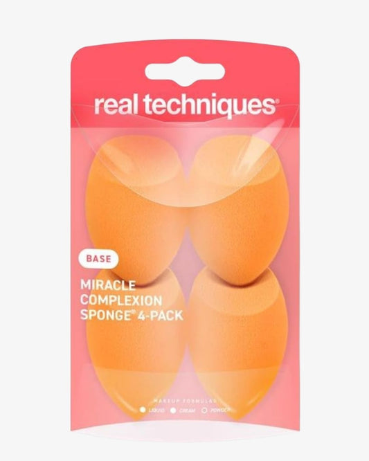 Real Techniques Miracle Complexion Sponge 4-Pack in a pink blister pack, containing four orange makeup sponges.